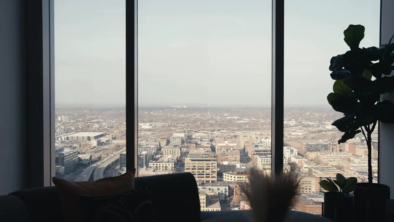 looking out the windows of a high rise condo building in a downtown city showing the landscape below tight push in