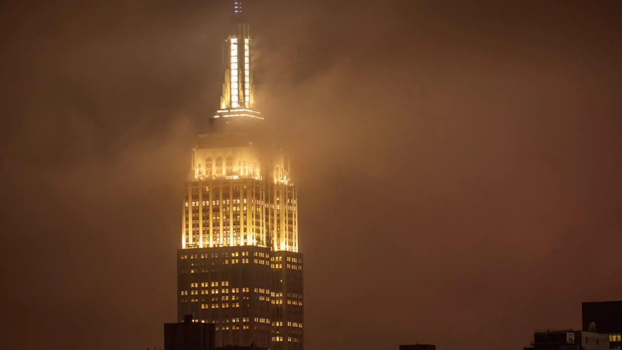 Time Lapse of clouds at the luminous tower of Empire State Building at a rainy night in Manhattan New York City