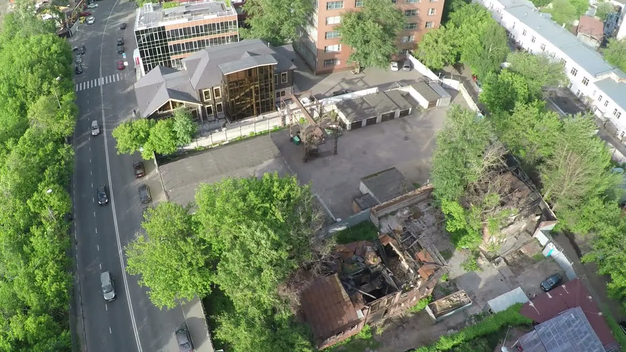 Aerial shot of street with car traffic and ruined house