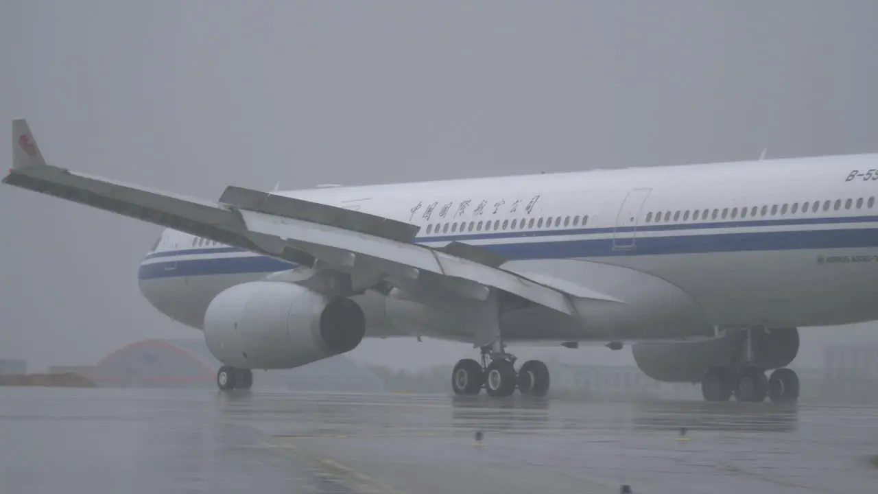 Air China airplane taxiing on wet runway at the airport