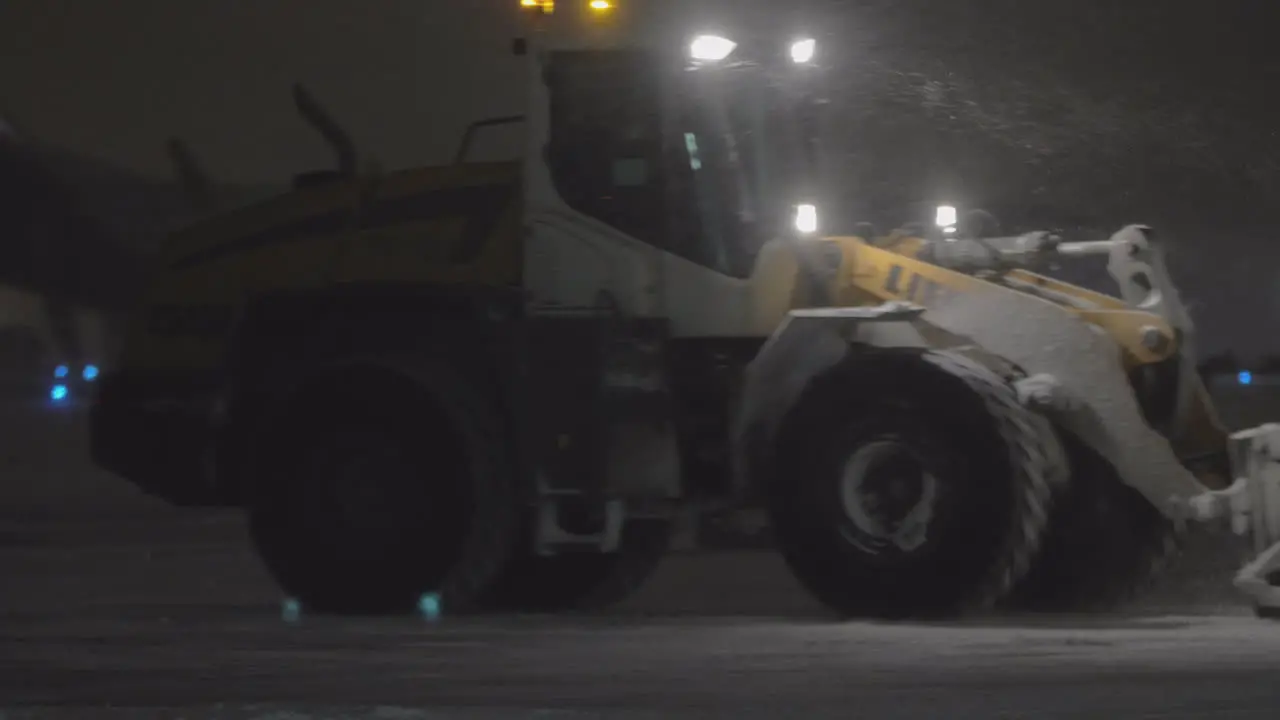 Tractor snow plow in the airport at night