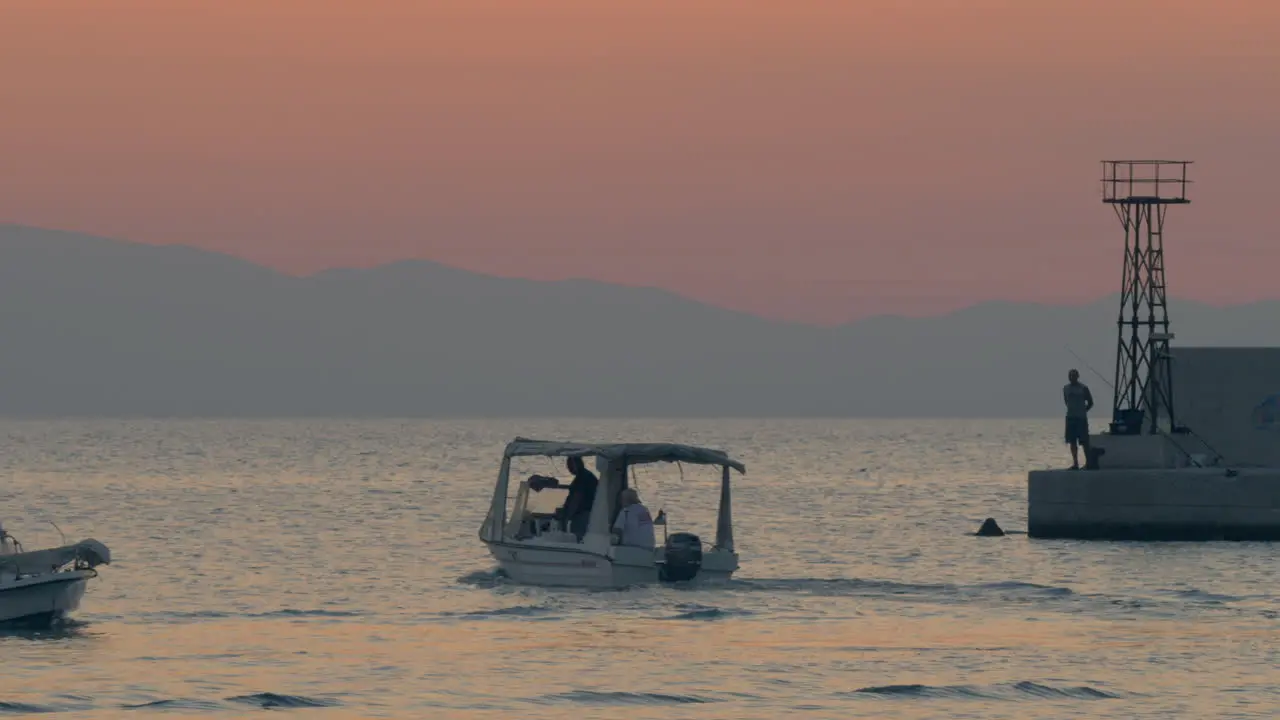 Motor boats sailing in quiet sea near the quay evening scene