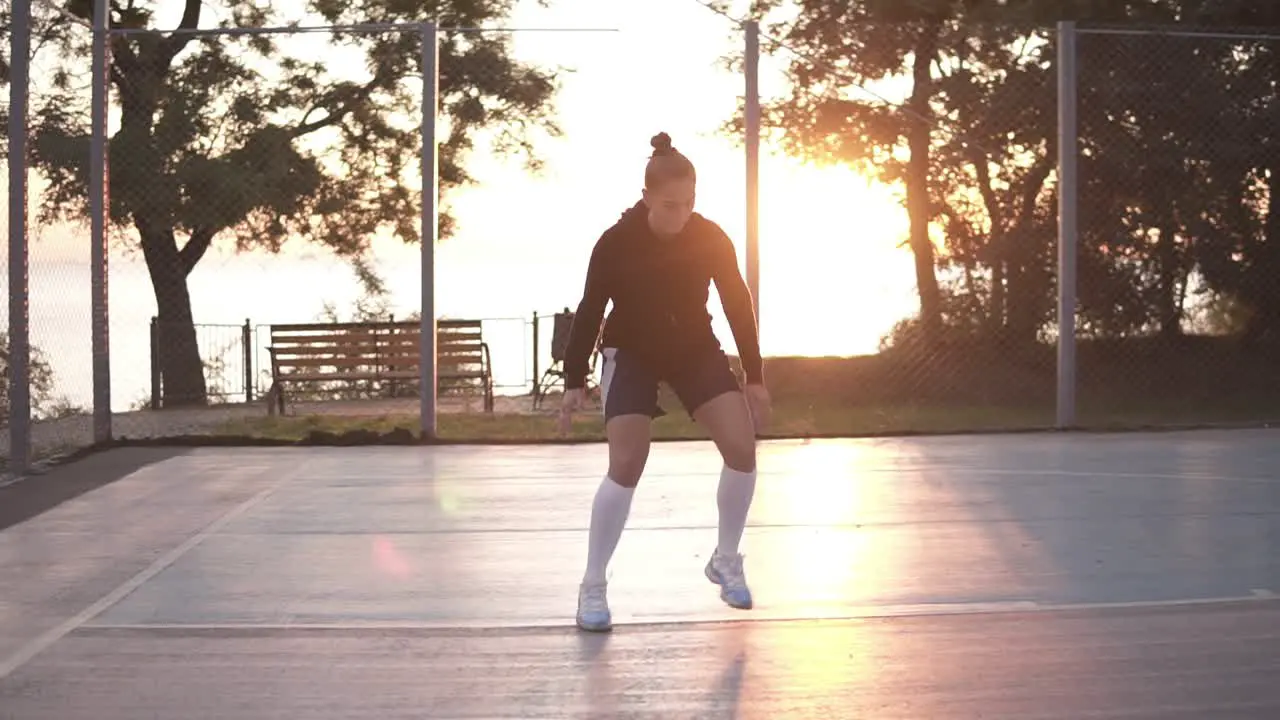 Full Lenght Shot Of Female Basketball Player Doing Legs Dribbling Exersice Very Quickly Training Outdoors On The Local Court