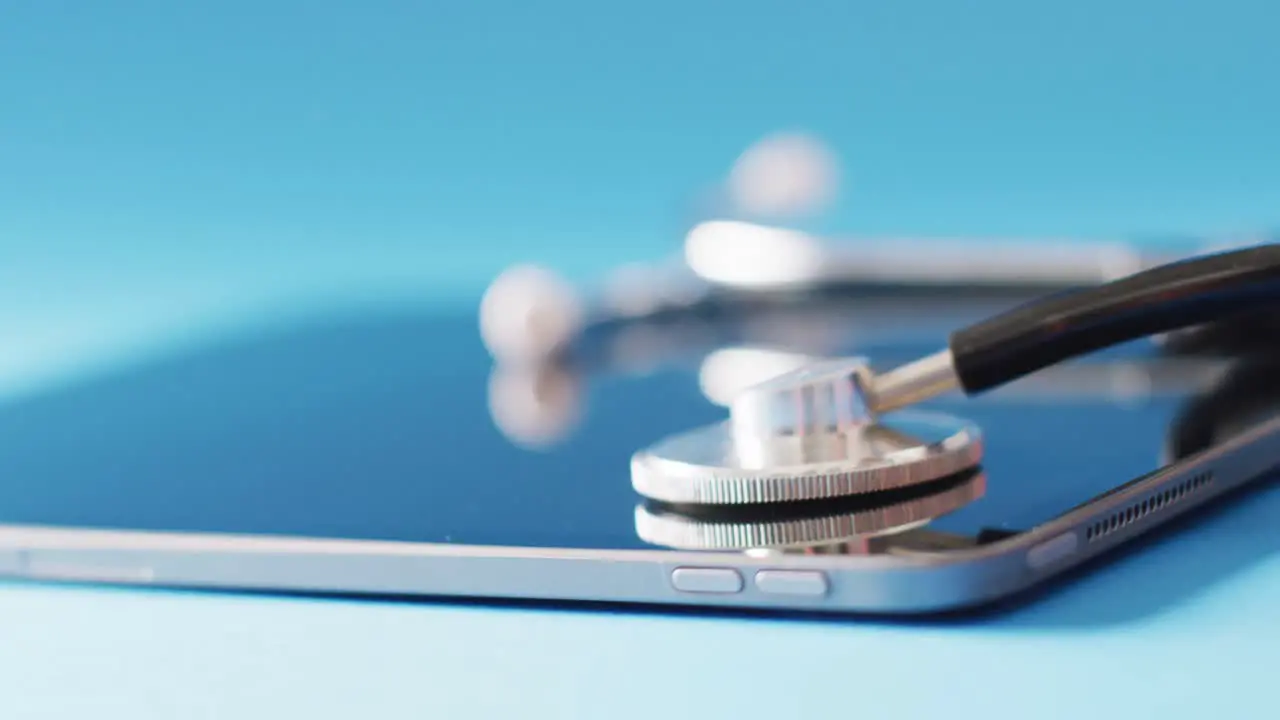 Video of stethoscope and tablet on blue background with copy space