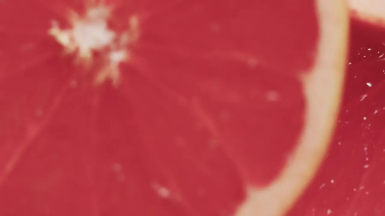 Micro video of close up of slices of red grapefruit with copy space