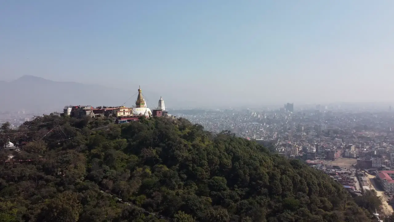 A view of the Swayambhunath Stupa on the top of a hill with the city of Kathmandu Nepal and the Himalayan Mountains in the background