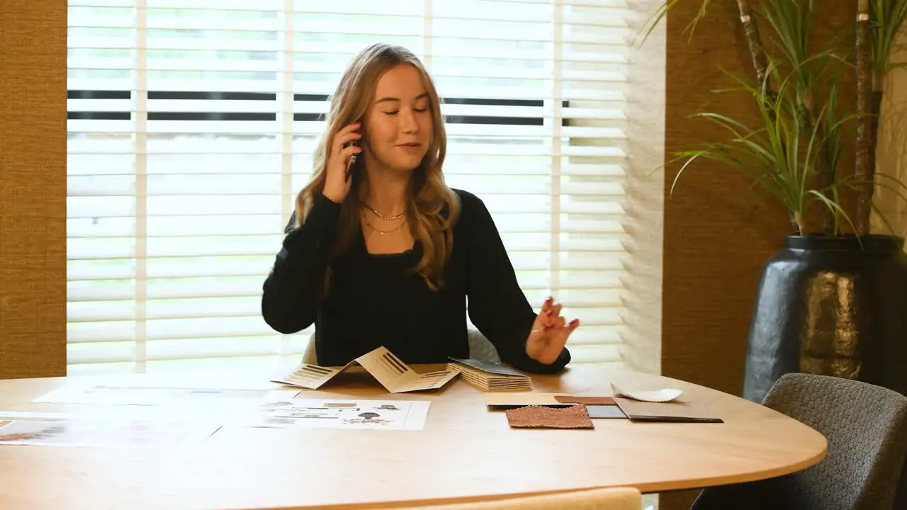 An interior stylist taking a calls and laughing