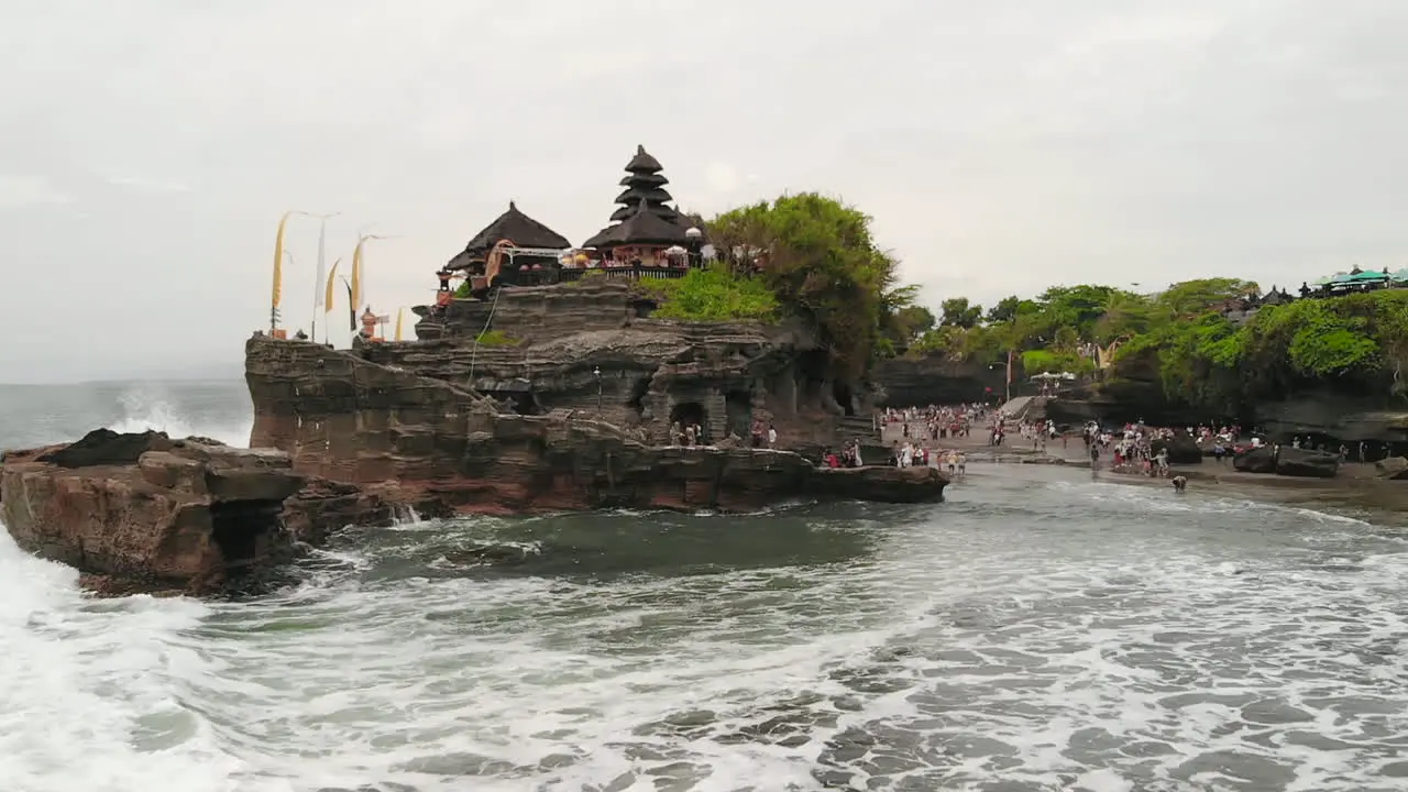 Drone flying closely over the popular Pura Tanah Lot temple in Bali