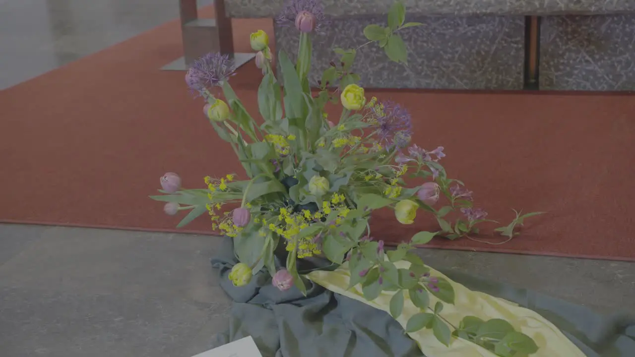 Bouquet of yellow and purple flowers on the floor in front of an altar