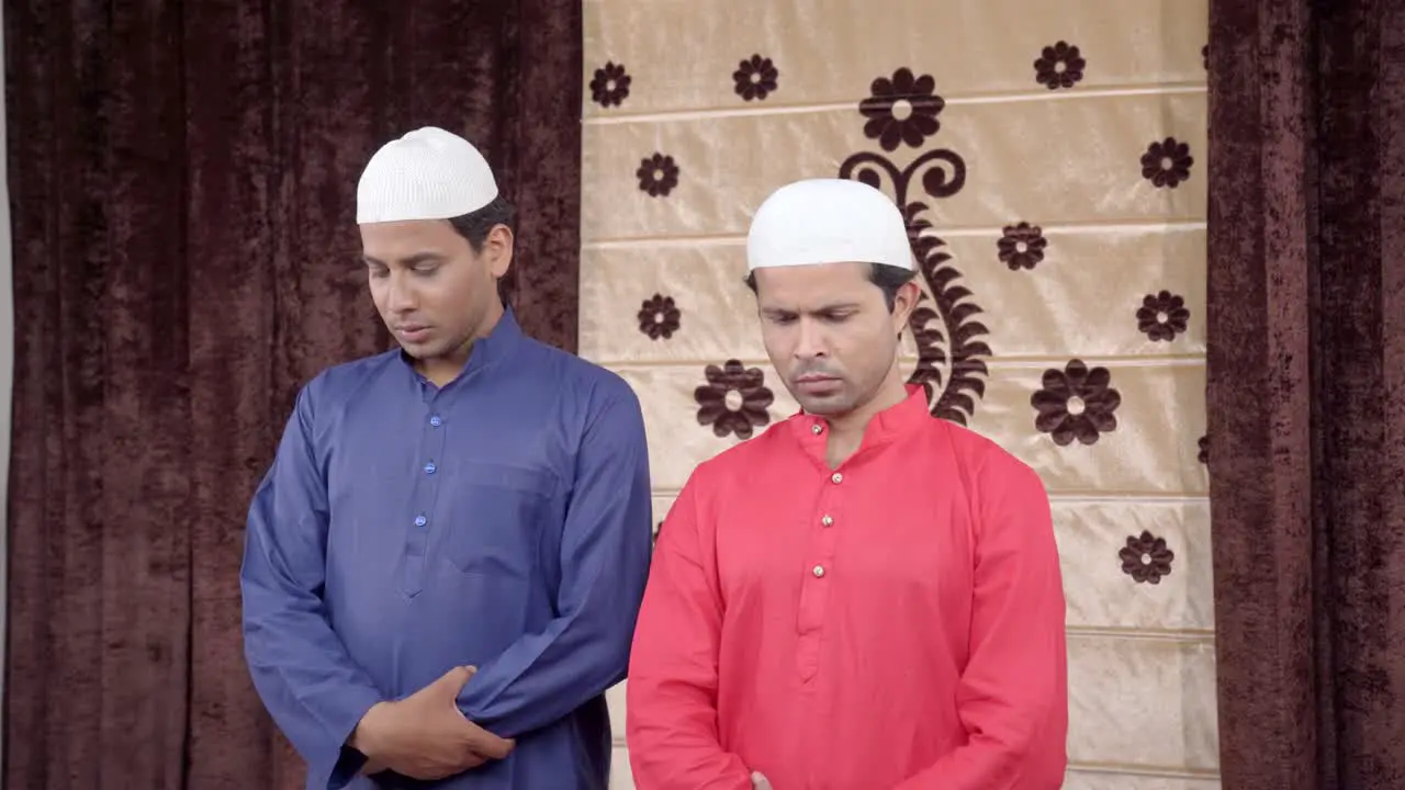 Two muslim men showing doing Eid prayer