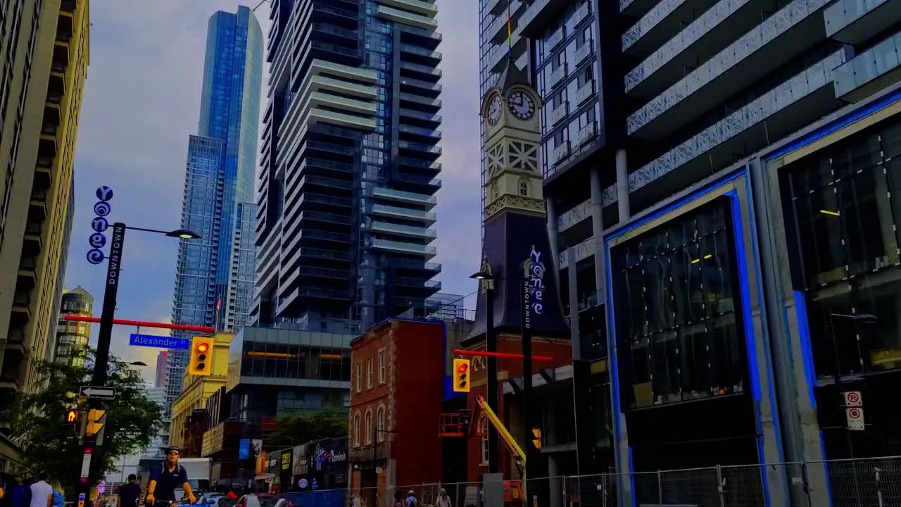 Toronto Yonge and Alexander South rainy sunny after rainfall while new building being erected in a post modern architectural design skyline view traffic light intersection with vintage clock tower