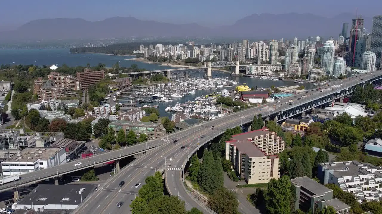 3-4 Aerial panout over Upper Granville Island residential commercial community and bridge leading downtown over the False Creek yacht parked boating clubs on a lush summer lockdown pandemic afternoon