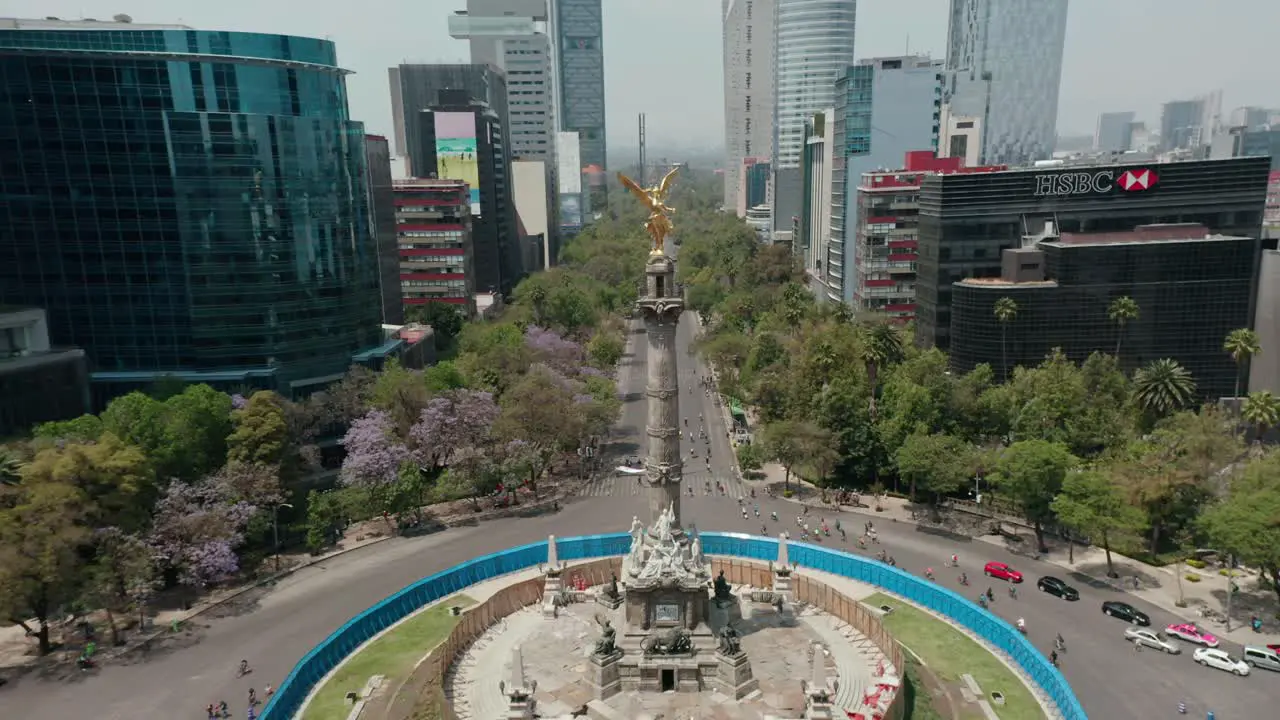 Aerial dolly out of angel of independence monument in mexico city with cyclists