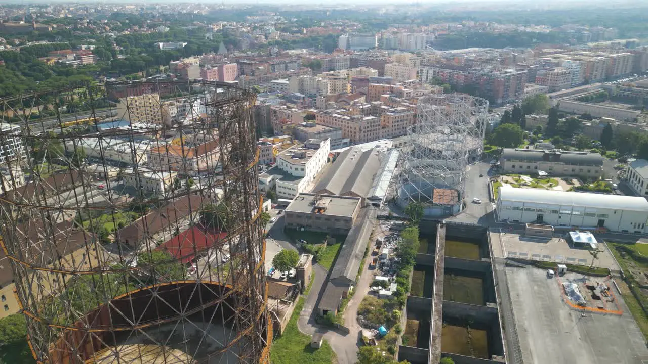 Aerial drone forward moving shot flying high over old iron structure Gazometro with the view of Ostiense district Rome in Italy on a sunny day