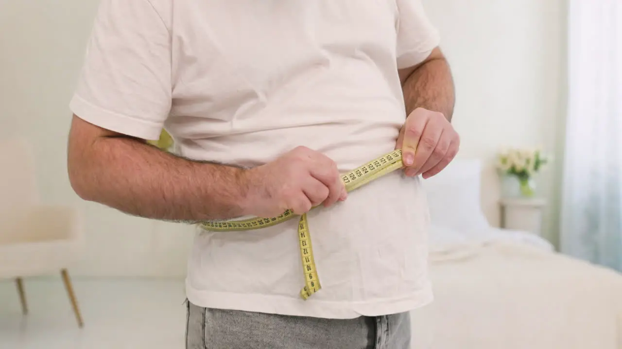 Unrecognizable Boy Measuring His Waist In The Bedroom 1