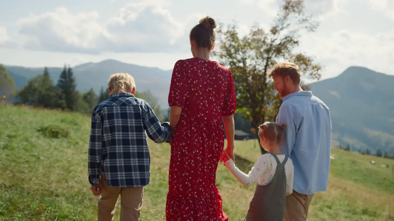 Family spending vacation meadow sunny day Parents walking grass with children