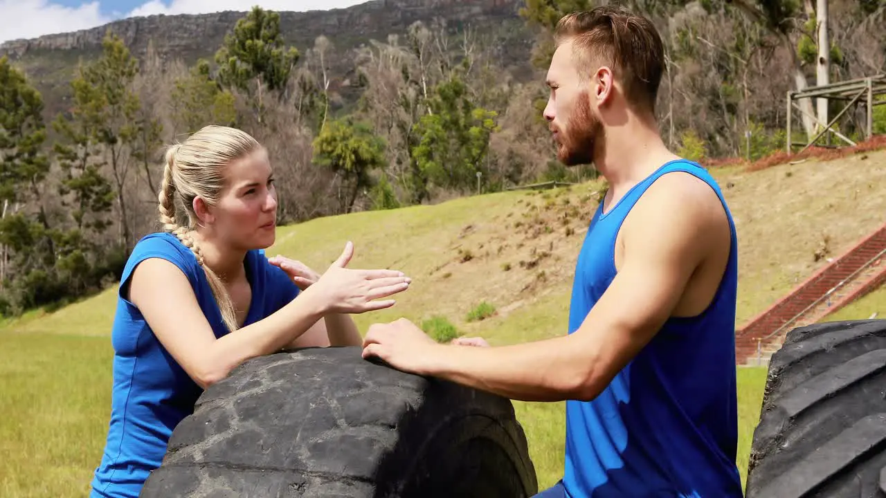 Fit man and woman interacting with each other during obstacle course