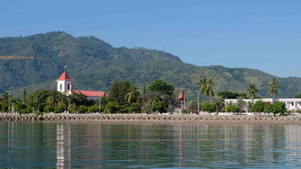 The historic Church de Santo António de Motael oldest Roman Catholic church from waterfront with daily city traffic in the capital Dili Timor Leste Southeast Asia