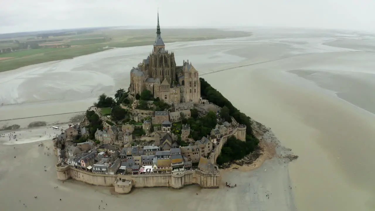 mont saint michel drone camera looking back there are many tourists coming back after seeing the castle