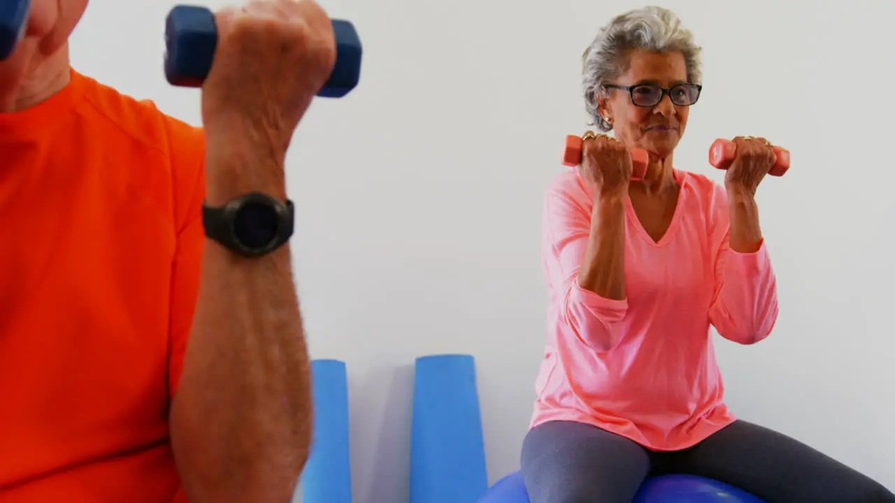 Mixed race senior people exercising with dumbbells in the fitness studio 4k