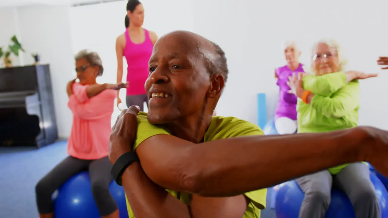 Front view of Caucasian female trainer training senior people in exercise at fitness studio 4k