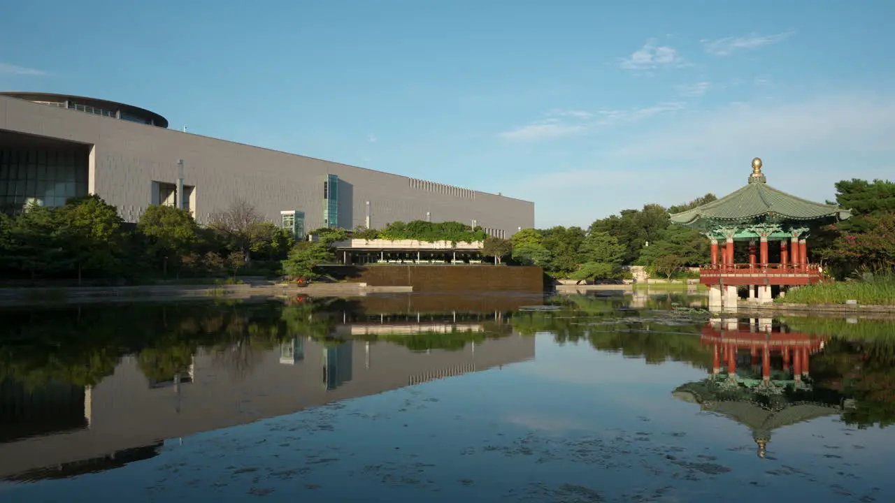 Cheongjajeong Pavilion and National Museum of Korea on Summer Sunny Day with Reflections in Water in Seoul City Yongsan District pan reveal