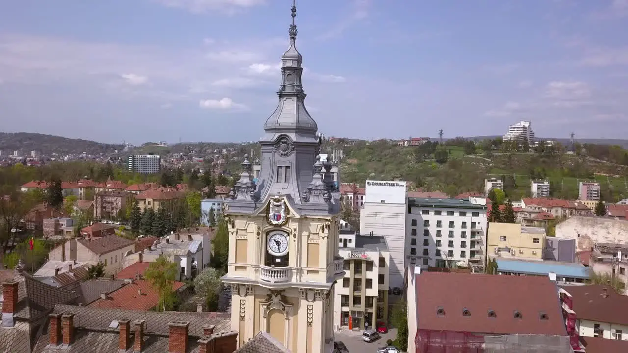 Aerial Drone Shot Pushing in towards a Beautiful Clock Tower Before Revealing the Cityscape of Cluj Napoca Romania