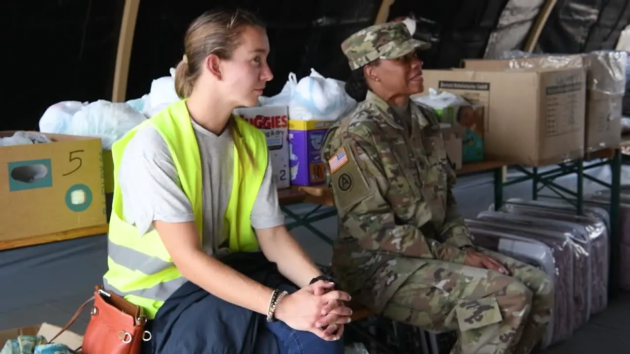 Female Soldier And Red Cross Personnel Planning Session About Distributing Food And Infant Supplies Operation Allies Refuge