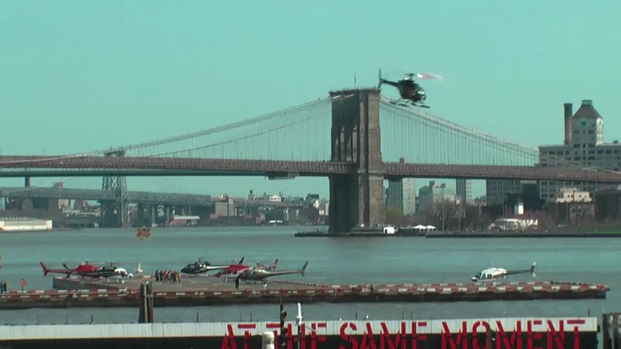 Helicopter taking off from Pier 6 at East River with Brooklyn Bridge in the background