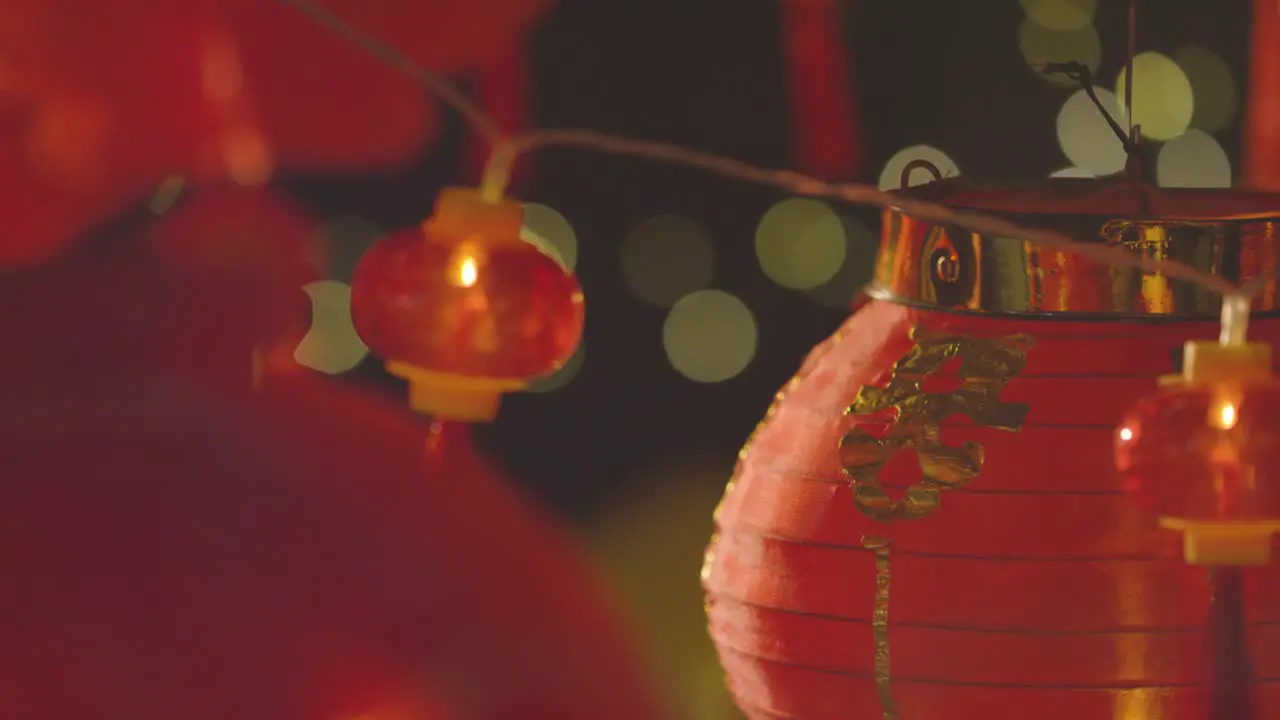 Close Up Of Colourful Chinese Lanterns And Lights Celebrating New Year Hung Against Black Background