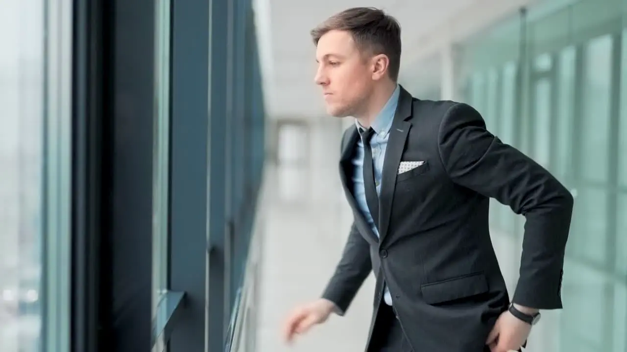 Angry businessman standing by the window in despair