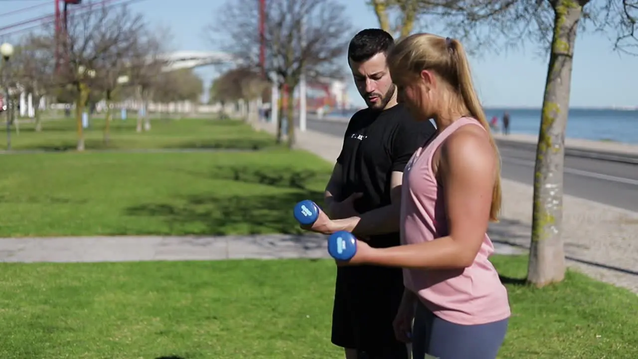 Side view of focused woman training arms with dumbbells