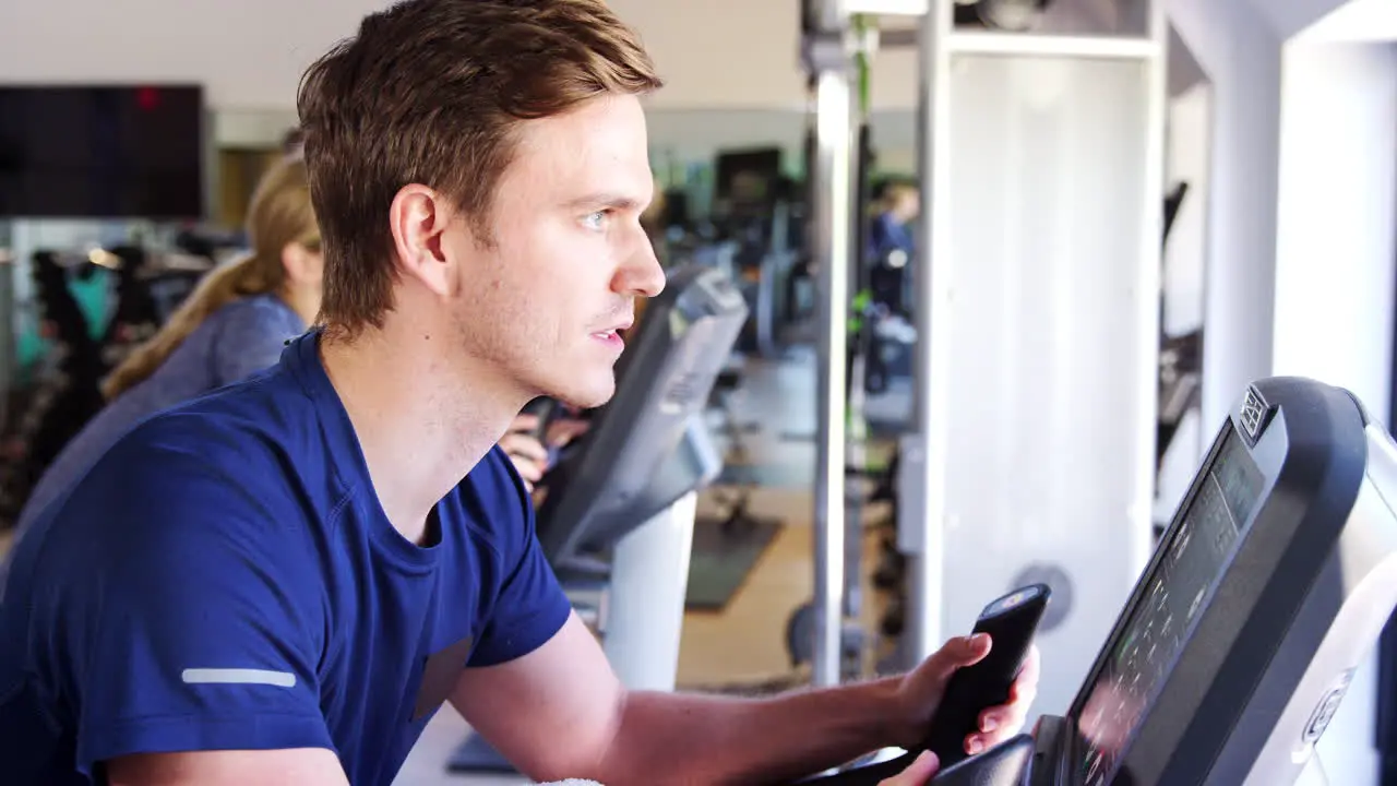 Man Exercising On Cycling Machine In Gym