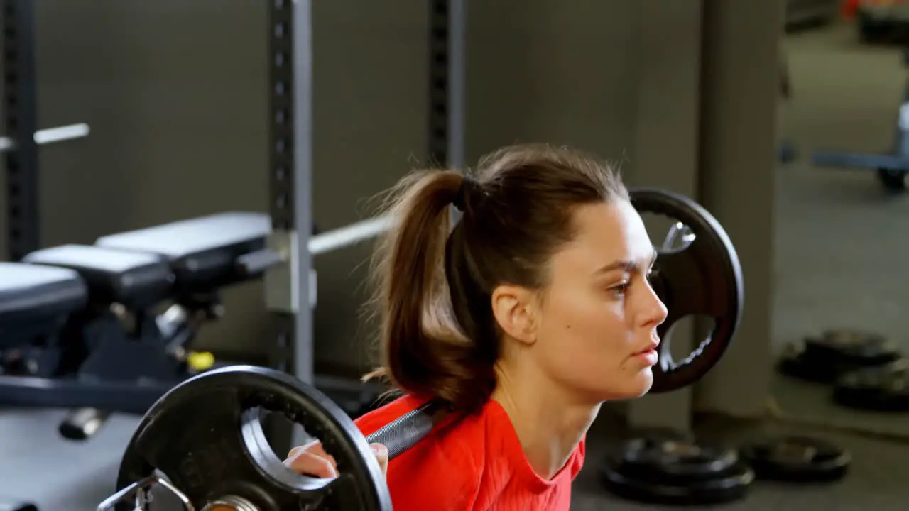 Woman exercising with barbell in a fitness studio 4k