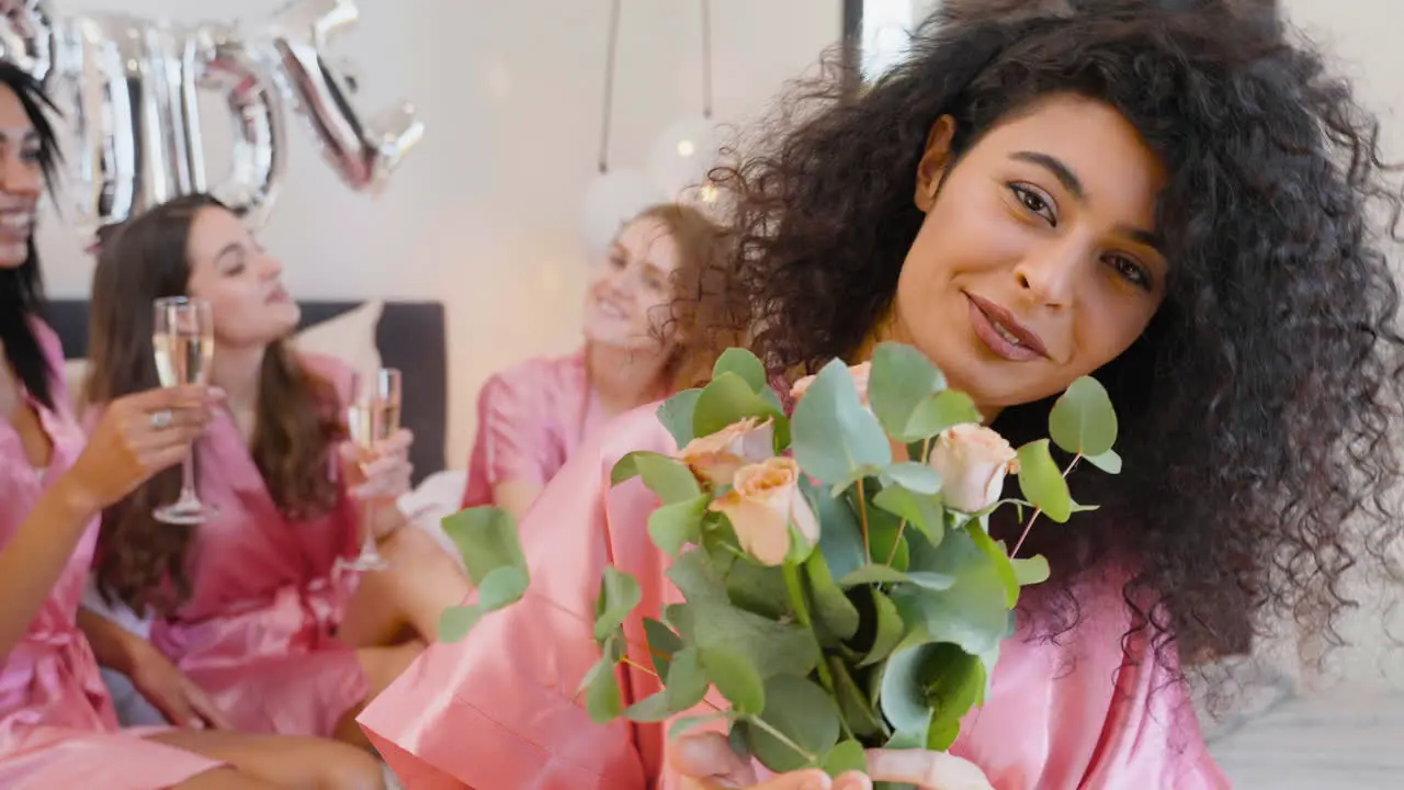 Muslim Woman Holding Bouquet Wearing Pink Silk Nightdress Smiling And Looking At Camera 1