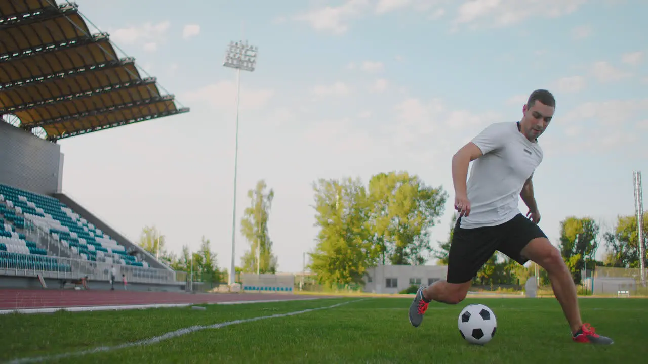 Un Jugador De Fútbol En El Estadio Demuestra Cómo Driblar Con Un Balón De Fútbol Mientras Corre Con Una Espada Excelente Habilidad De Un Jugador De Fútbol Y Control Del Balón