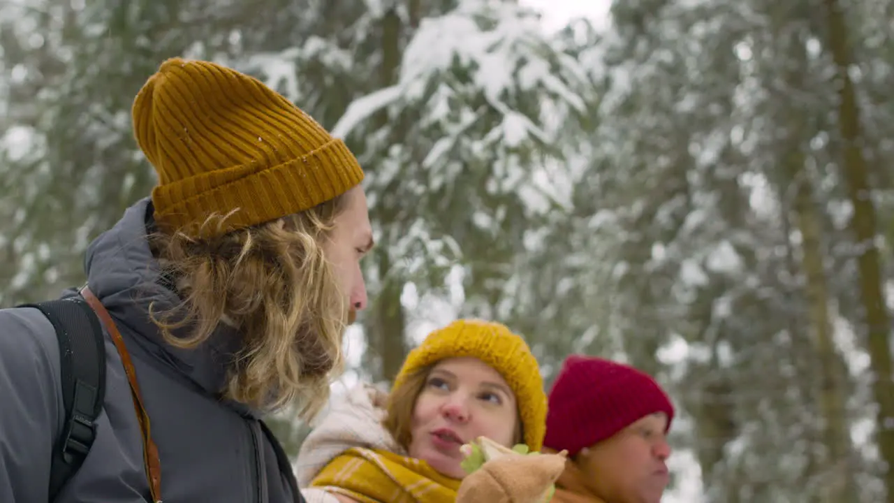 Unteransicht Von Drei Freunden Die Beim Essen In Einem Verschneiten Wald Sitzen Und Reden