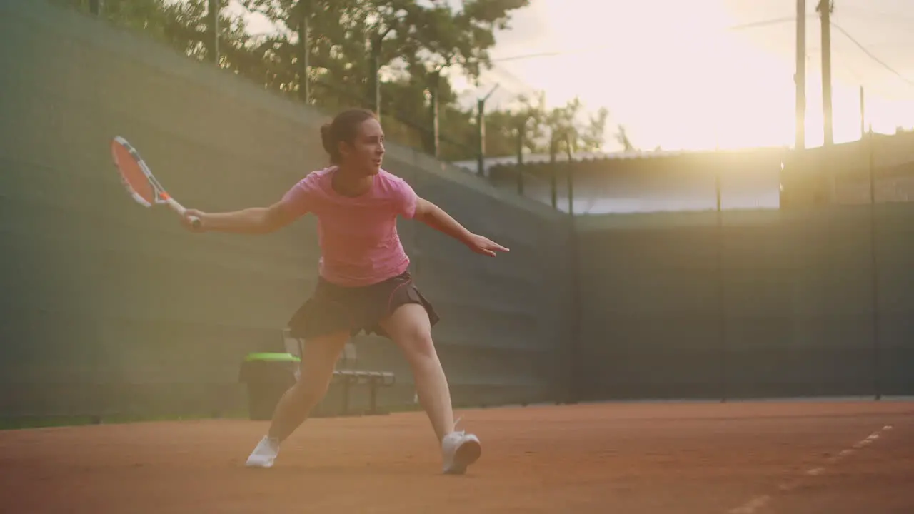 Eine Junge Brünette Tennisspielerin Spielt Bei Sonnenuntergang Auf Einem Tennisplatz Einen Ball Eine Frau Spielt Professionell Und Dynamisch Tennis In Zeitlupe