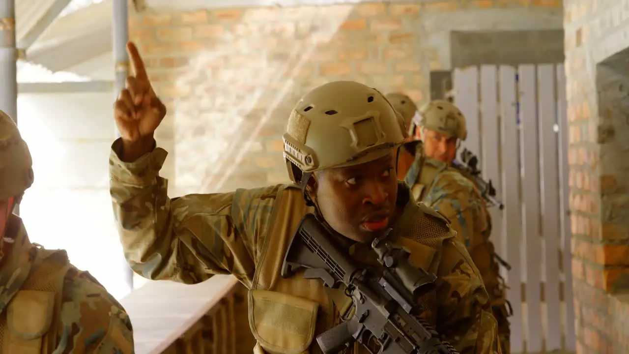 Front view of mixed-race military soldiers walking with rifles during military training 4k