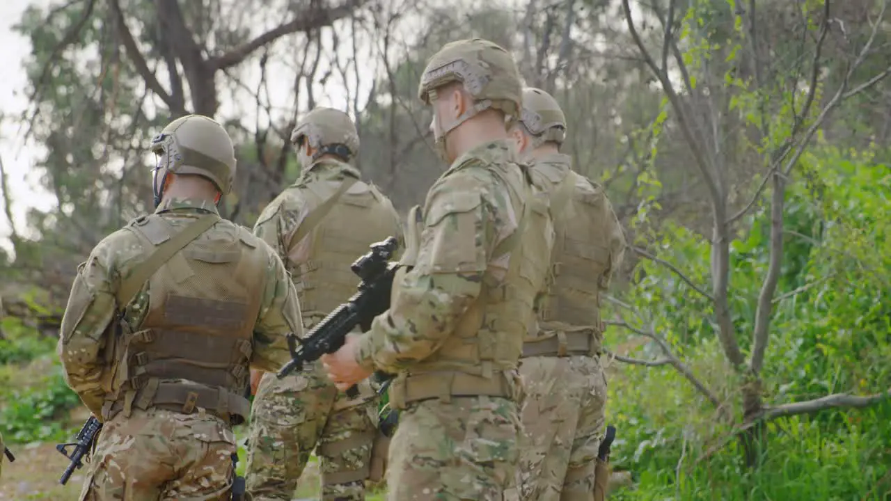 Rear view of mixed-race military soldiers rifle training in fields during military training 4k 