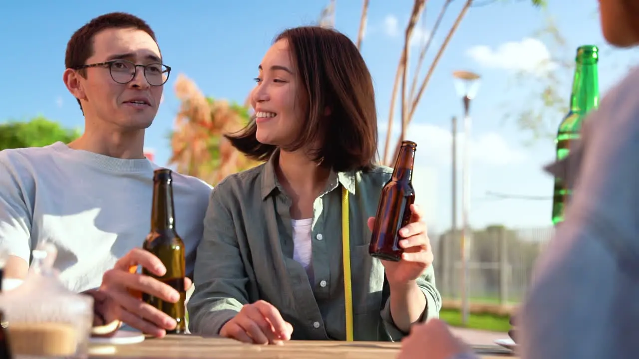 Gruppe Von Drei Glücklichen Japanischen Freunden Die Mit Bier Anstoßen Während Sie An Einem Sonnigen Tag Draußen Am Tisch Sitzen