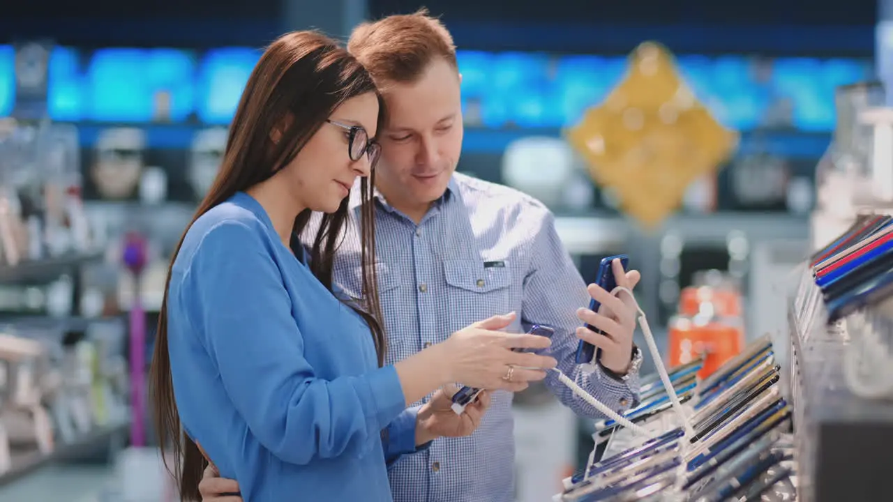 Pareja Feliz Comprando Un Nuevo Teléfono Inteligente En Una Tienda De Tecnología Decidir Qué Modelo Comprar