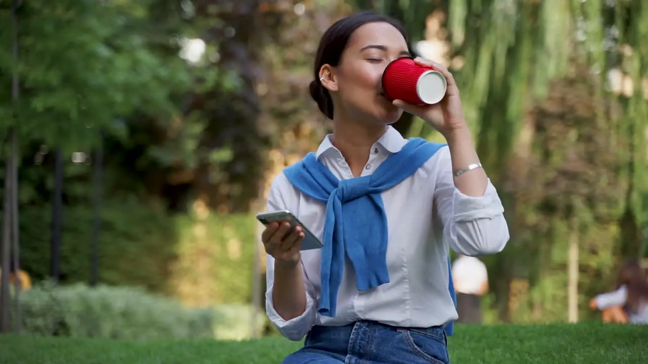 Mujer Leyendo Mensajes En Su Teléfono Y Tomando Un Café Al Aire Libre