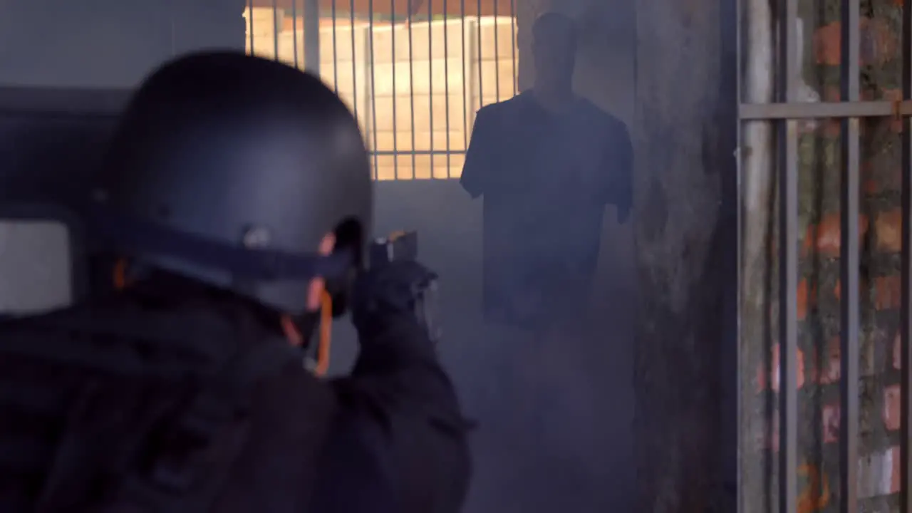 Rear view of caucasian military soldier firing with pistol on rubber dummies during training 4k