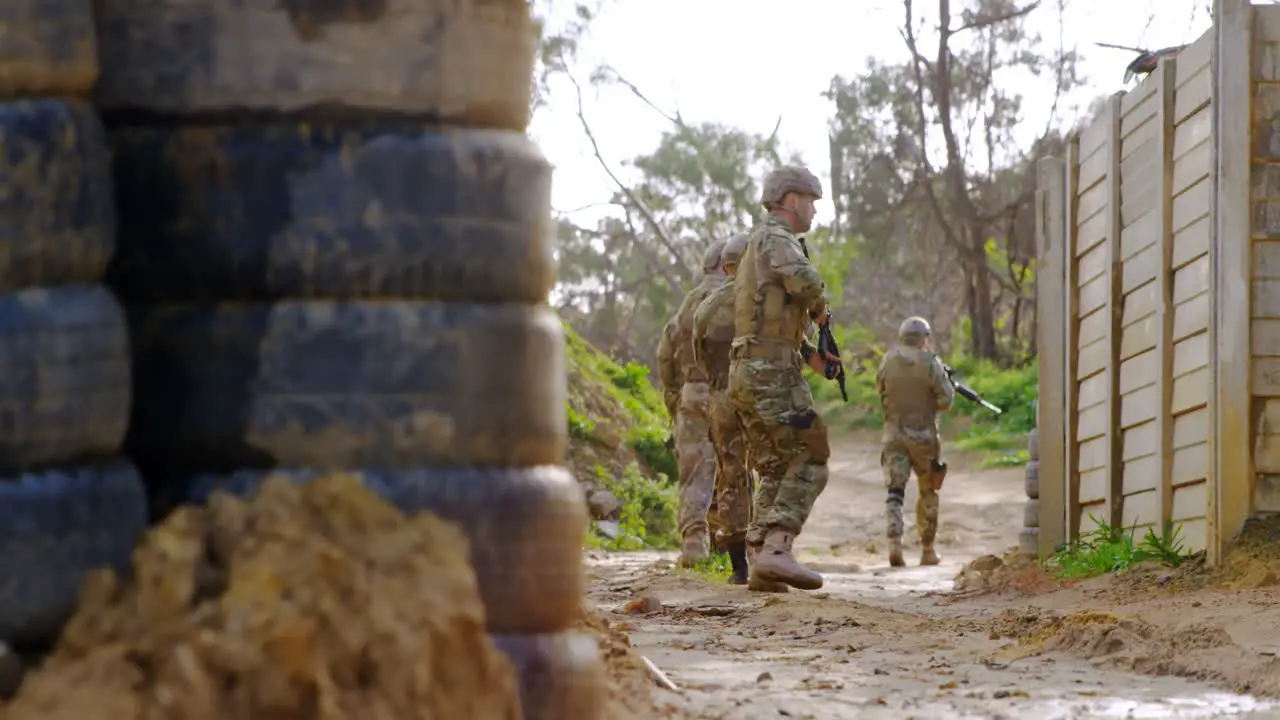 Front view of caucasian military soldier walking with rifle during training 4k