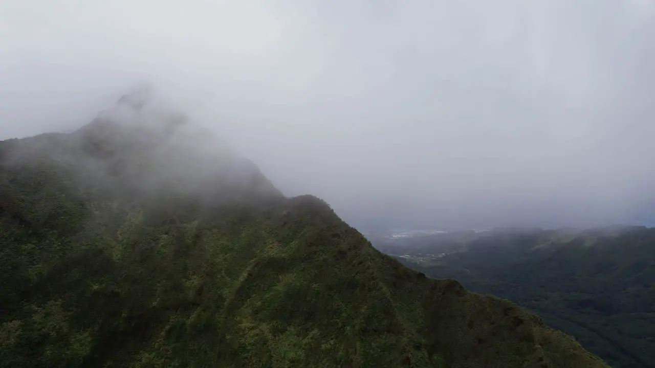 Nu‘uanu Pali area Clouds over cliff slow push forward over ridge on a moody day