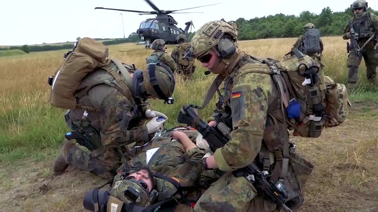 German Soldiers Participate In A Rescue Operation In A Field With A Military Helicopter Landing In The Background 2