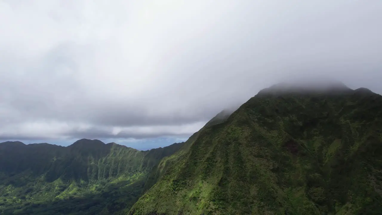 Nu‘uanu Pali overlooking cliff with clouds ascending while orbiting