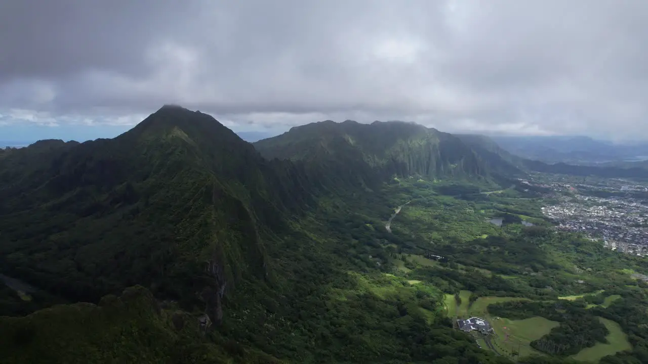 Nu‘uanu Pali overlooking cliff with city scape in the distance flying backwards