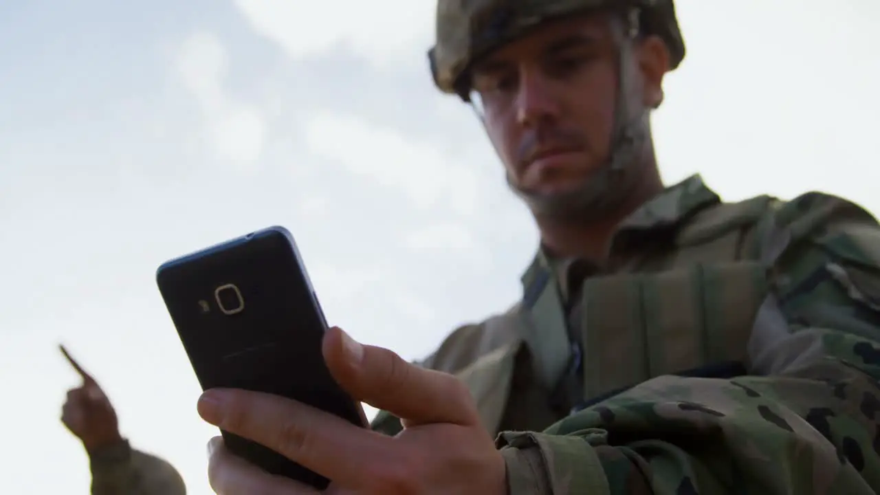 Low angle view of military soldier using mobile phone during training 4k